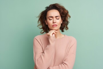 Wall Mural - Medium shot portrait photography of a woman in her 30s appearing tired and down due to hypothyroidism wearing a chic cardigan against a pastel or soft colors background 