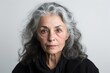 © Leon Waltz - Close-up portrait photography of a woman in her 50s with a somber and deeply sad expression due to major depression wearing a chic cardigan against a white background