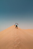 Fototapeta Góry - Boy running up sand dune