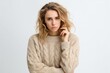 © Leon Waltz - Medium shot portrait photography of a woman in her 30s visibly in discomfort and fatigue from an autoimmune disease like lupus wearing a cozy sweater against a white background
