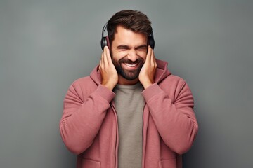 Wall Mural - Careless Serenity. Portrait of an Indifferent and Carefree Male Model Enjoying Inner Peace by Covering his Ears over Gray Wall. Generative AI