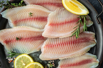 Poster - raw fish fillet with lemon and spices on a dark background. top view