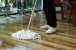 Close-up of mop that is being hit by cafe worker Mopping floor of the cafe after closing. Small business, family restaurant and coffee shop. to prepare to support customers next day to use service..