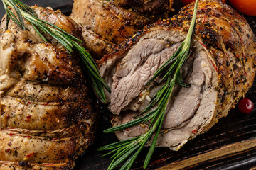 The concept of German cuisine. Baked pork knuckle with spices and herbs, tied with thread, lies on a wooden board.