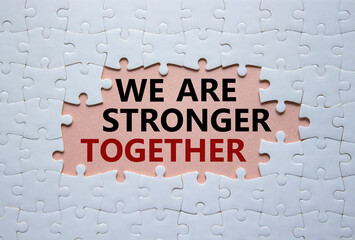 We are stronger together symbol. White puzzle with words We are stronger together. Beautiful pink background. We are stronger together concept. Copy space.