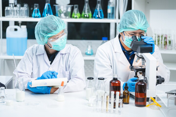 Wall Mural - Food scientist testing new stuff samples of dairy products in the laboratory, female laboratory assistant checks a quality of milk, bottles glassware and glasses of milk to testing lactose forms