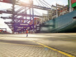 © Connect Images - Dock worker standing by cargo ship in sunlight, Felixstowe, England.