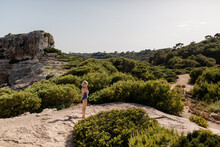 Girl Exploring A Path Between Shrubs At Calo Des Moro In Mallorca