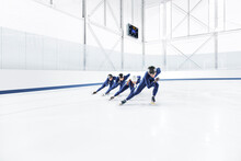 A Team Of Speed Skaters Practicing At An At Ice Rink