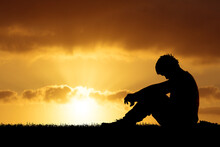 Silhouette Of A Man Who Is Lonely And Desperate Due To Heartbreak And Losing His Job Due To The Economic Crisis.