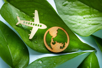 symbol of modern air transport, Electric airplane, airplane and earth icon on green leaves background, environmental and business concept, co2 reduction