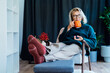 © okrasiuk - Middle aged woman relaxing with pumpkin shaped cup of hot drink in scandy style hygge interior home with fall mood decor. Lady dreaming, enjoy calm mood without stress, well being alone. Cozy autumn.