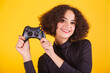 © StockImageBrasil - Caucasian model, in black shirt and blue jeans, holding joystick, gamer. fun.