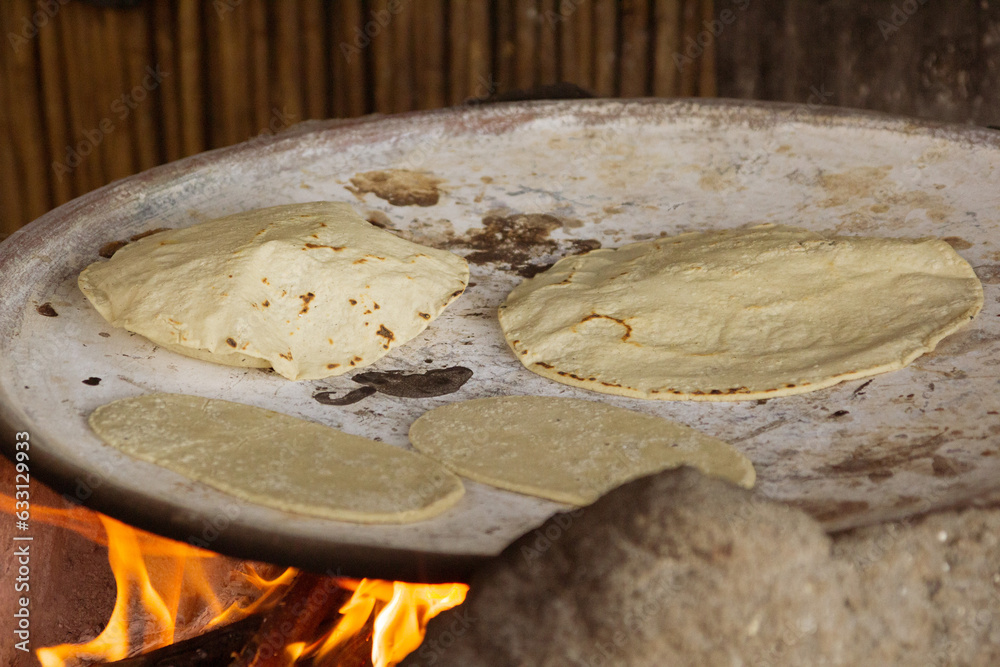 Foto de Stock Deliciosas tortillas de maíz hechas a mano sobre un comal