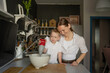 © ADDICTIVE STOCK - Woman and boy mixing batter in bowl in kitchen