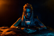 Photo Of Mysterious Viking Mythology Wizard Woman Hold Elixir Cup Yellow Lights Isolated On Black Color Background