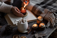 Aromatherapy On A Grey Fall Morning, Atmosphere Of Cosiness And Relax. Autumn Cozy Home Composition With Hot Chocolate With Marshmallow And Candles. Wooden Background, Books, Close Up.