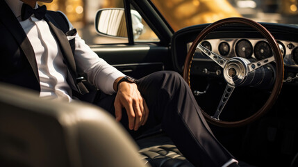 Wall Mural - A man wearing a tuxedo and dress shoes in the driver's seat of a vintage Ferrari against a backdrop of luxury race cars.
