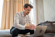 © Miljan Živković - One man adult Caucasian male work on laptop computer from hotel room