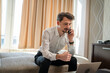 © Miljan Živković - One man adult Caucasian male work from hotel room make a phone call