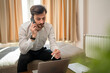 © Miljan Živković - One man adult Caucasian male work from hotel room make a phone call