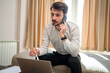 © Miljan Živković - One man adult Caucasian male work from hotel room make a phone call
