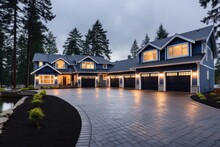 The Home Has An Elegant Exterior Featuring Blue Vinyl Siding And White Accents. A Lengthy Concrete Driveway Leads To Three Connected Garage Spaces. The Overall Appearance Of The Property Is Visually