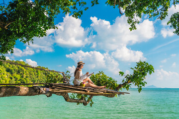 Wall Mural - Traveler woman on tree branch using tablet joy nature scenic landscape Railay beach Krabi, Digital nomad work travel Phuket Thailand summer holiday vacation trip, Tourism beautiful destination Asia