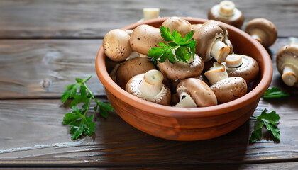 Wall Mural - Fresh mushrooms in a clay bowl and parsley on a dark rustic wooden table. Vegetarian food is on the table.