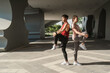 © ME Image - Young Asian couple stretching together before jogging exercise in urban area. Warming up for workout outdoor in the morning.