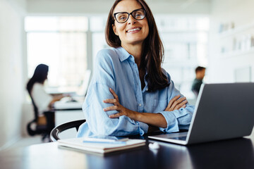 Poster - Female web developer sitting with a laptop in an office