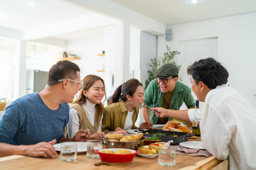 Wall Mural - Group of Cheerful Asian man and woman eating food and drinking wine celebration dinner party together at home. Happy people friends enjoy and fun celebrating reunion meeting holiday event vacation.
