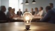 Company meeting with a lightbulb in the front suggesting brilliant business ideas 