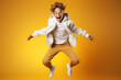 © wolfhound911 - Portrait of jumping African-American teenage boy on yellow background.