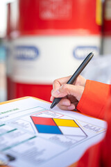 Wall Mural - a safety officer is checking on the hazardous material checklist form with chemical storage area at 