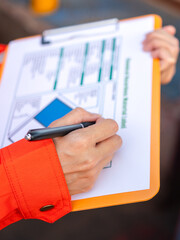 Wall Mural - action of a supervisor is using a pen to writing on chemical hazardous material paper form to rating