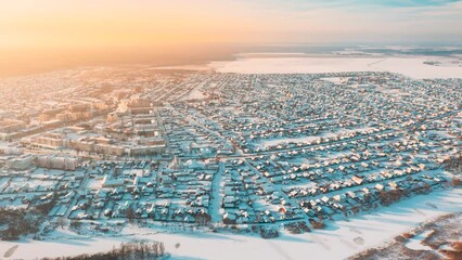 Poster - Aerial View Of Town Village Cityscape Skyline In Winter Sunny Morning. Sunrise Timelapse Dronelapse Hyperlapse. Residential Houses, Traffic In Snowy Landscape. Bird's-eye View.