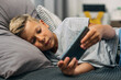 © cherryandbees - Preteen boy is using his phone in bed.