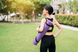 © Jirawatfoto - Yoga girl. Healthy lifestyle at sunset: Asian woman performs exercises with a rubber mat in the park. Wellness, fitness, and nature's tranquility.