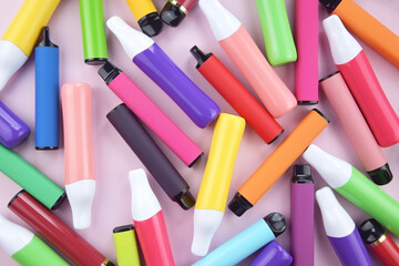 Wall Mural - Set of multicolor disposable electronic cigarettes on a pink background.