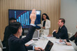 © NewSaetiew - Businesspeople discussing during meeting in conference room. Clean Energy Discussions Amidst Wind Turbines and Solar Panels. Harnessing Clean Energy.