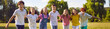 © Studio Romantic - Happy children standing in a line together outside and smiling in the park on holidays enjoying spending time in a summer camp. Portrait of a hugging kids looking outdoor at the camera. Banner.