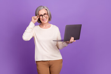 Sticker - Photo of intelligent old pensioner businesswoman touch glasses using laptop browsing clients data isolated over purple color background