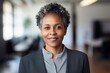 © Baba Images - Portrait of a middle aged african american businesswoman with short hair looking at camera in the office