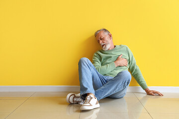 Sticker - Mature man having heart attack near yellow wall