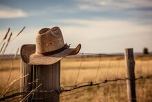 A Cowboy Hat On A Wooden Fence Post In A Grassy Landscap . Generative AI