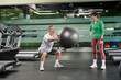 © LIGHTFIELD STUDIOS - excited senior man doing squats with fitness ball near woman, husband and wife in gym, couple, sport