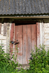 Rusty padlock closing a wooden door, closeup. An old wooden gate locked with an equally old rusty padlock. Vintage background