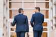 © Volodymyr - Businessmen talking on city street. Two colleagues business men walking outdoors on the street. Cheerful business conversation. Two businessmen walking outside business center, having conversation.