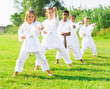 © JackF - Preteen childs, boys and girls, posing in fighting action on nature at the park